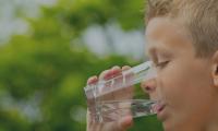 Barn drikker vand
