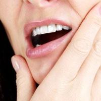 Kvinde holder sig på kæben på grund af tandsmerter